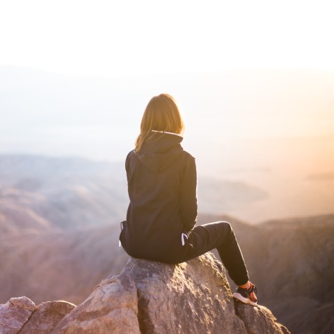 A woman sitting on a mountaintop