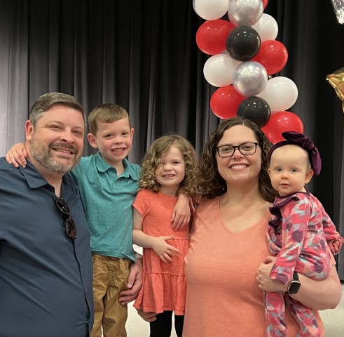 A photo of James with his wife and 3 children.